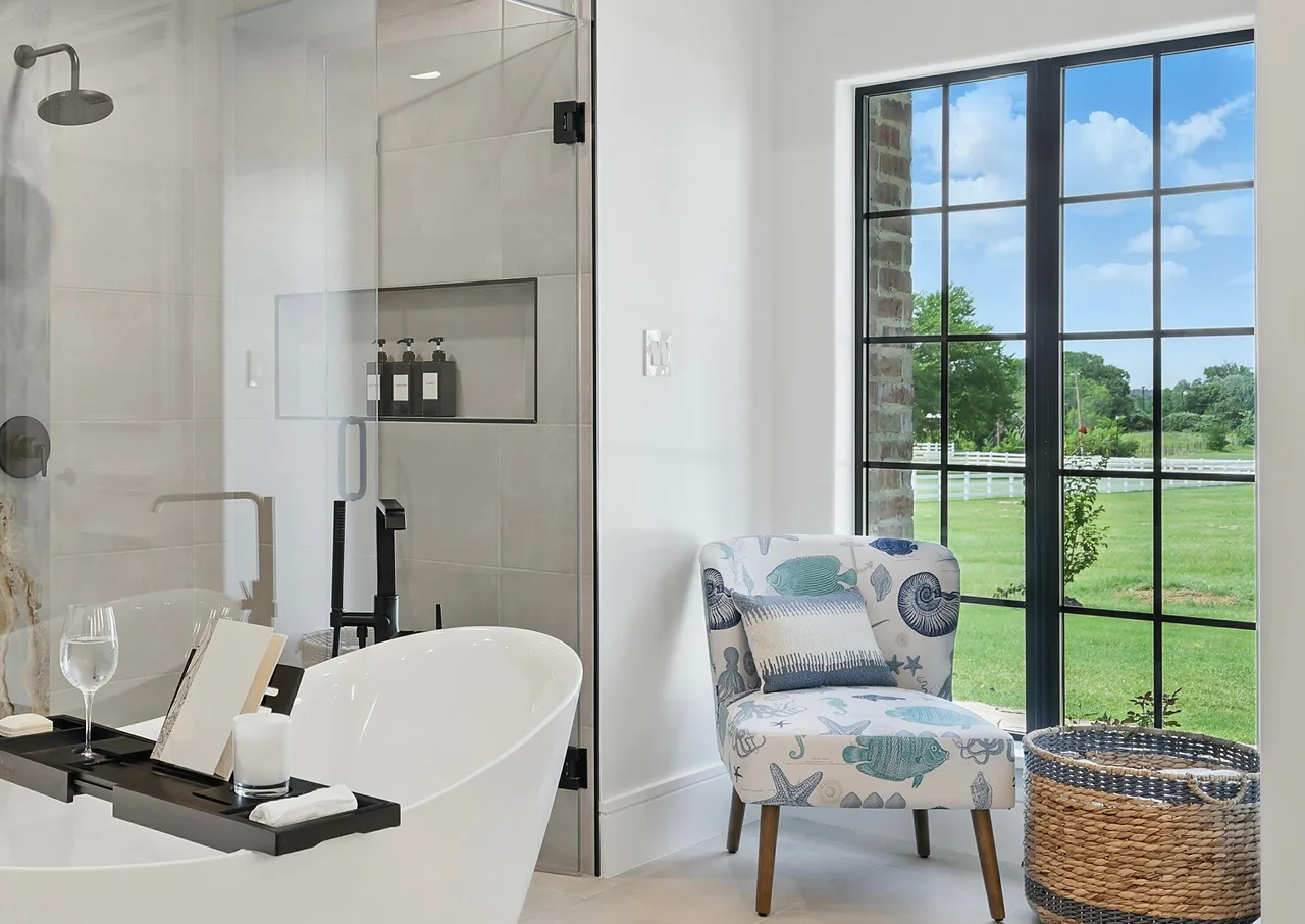 Freestanding soaking tub beneath steel-frame windows
